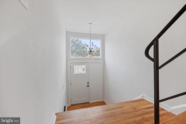 entrance foyer with a notable chandelier and light hardwood / wood-style flooring