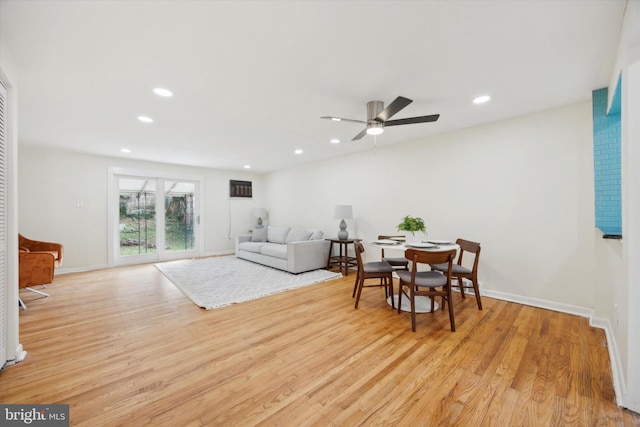 living room with light wood-type flooring and ceiling fan