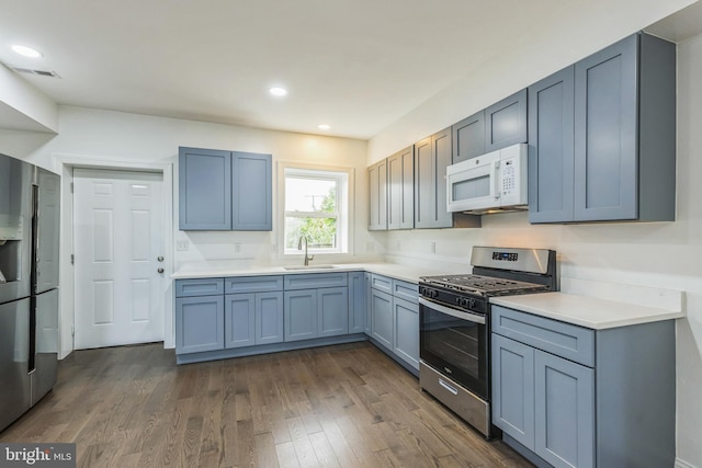 kitchen featuring appliances with stainless steel finishes, sink, and dark hardwood / wood-style flooring