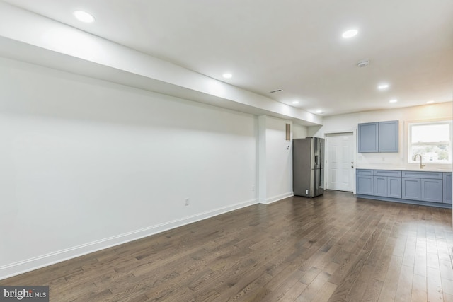 interior space with dark hardwood / wood-style flooring, sink, and stainless steel fridge