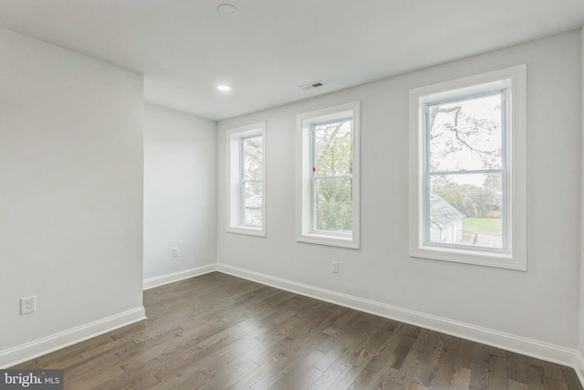 unfurnished room with dark wood-type flooring