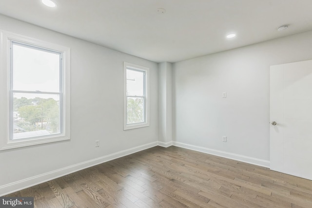 spare room with light hardwood / wood-style floors and plenty of natural light