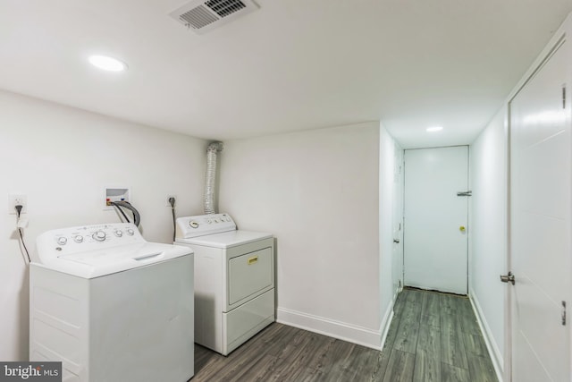 clothes washing area with washer and clothes dryer and dark wood-type flooring