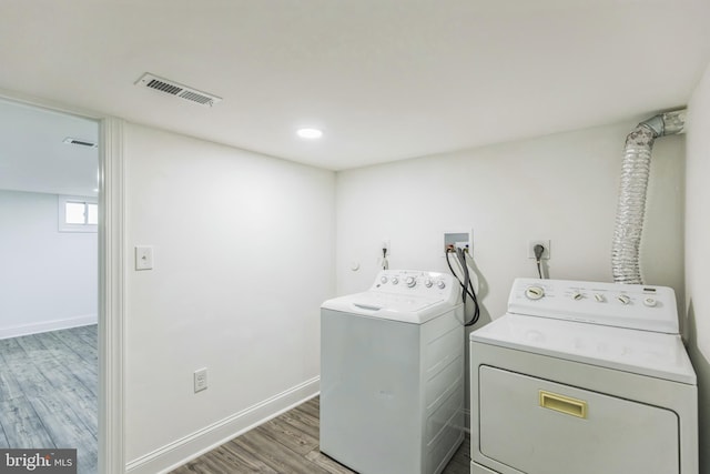 laundry room with hardwood / wood-style floors and washing machine and clothes dryer