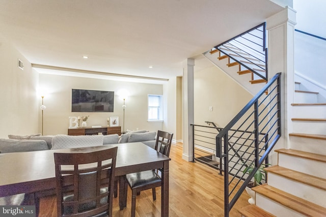 dining area with decorative columns and hardwood / wood-style flooring