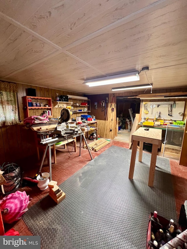 recreation room featuring wood walls and a workshop area