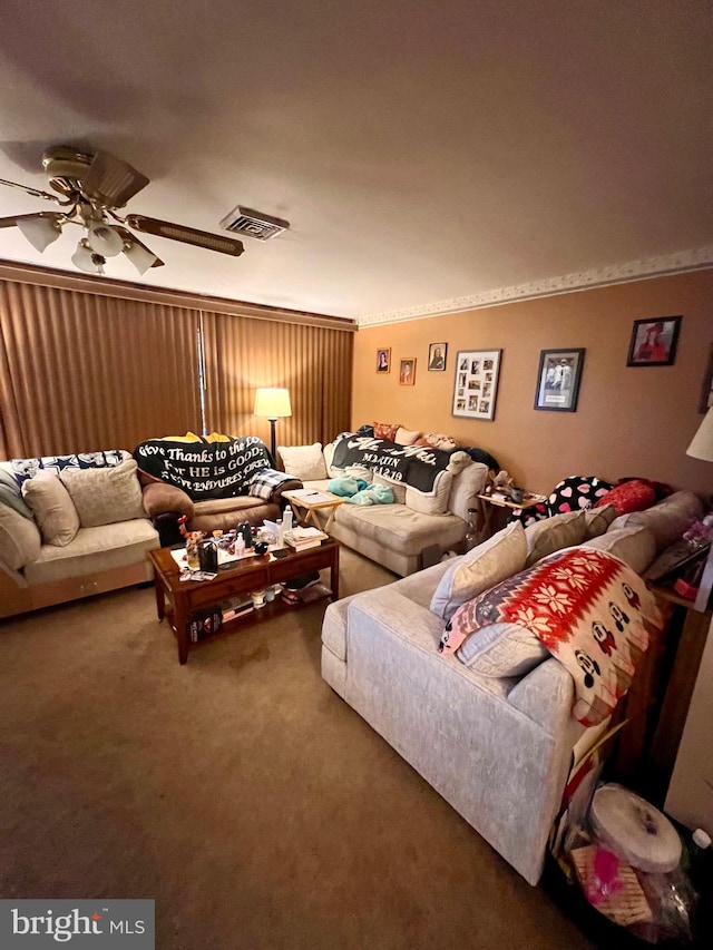 living room with carpet, ornamental molding, and ceiling fan