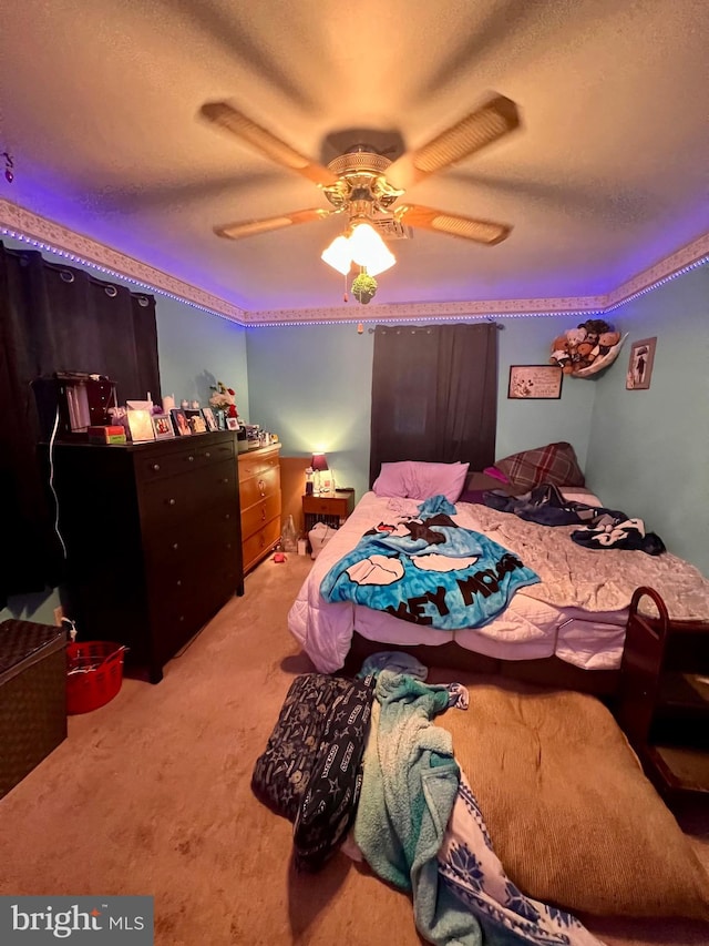 carpeted bedroom featuring a textured ceiling and ceiling fan