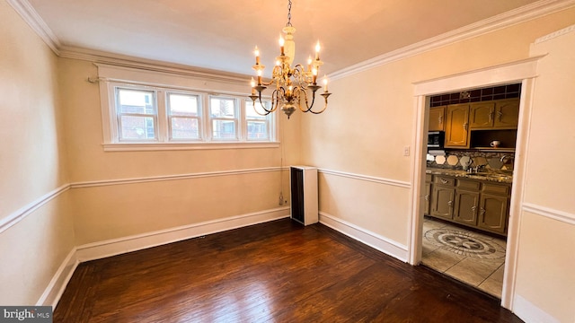 unfurnished dining area with an inviting chandelier, ornamental molding, and dark hardwood / wood-style flooring