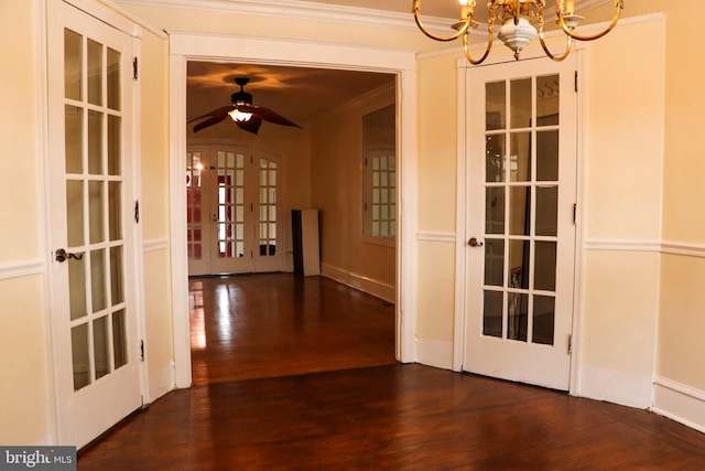 interior space with french doors, ornamental molding, ceiling fan with notable chandelier, and dark hardwood / wood-style flooring