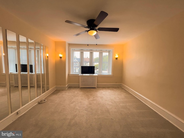 carpeted spare room featuring ceiling fan