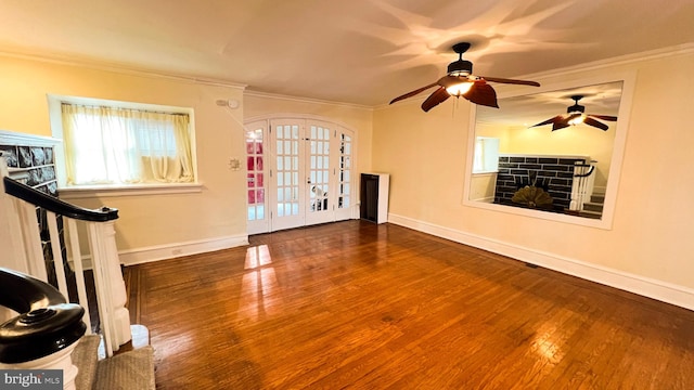 exercise area featuring ornamental molding, dark hardwood / wood-style flooring, ceiling fan, and french doors