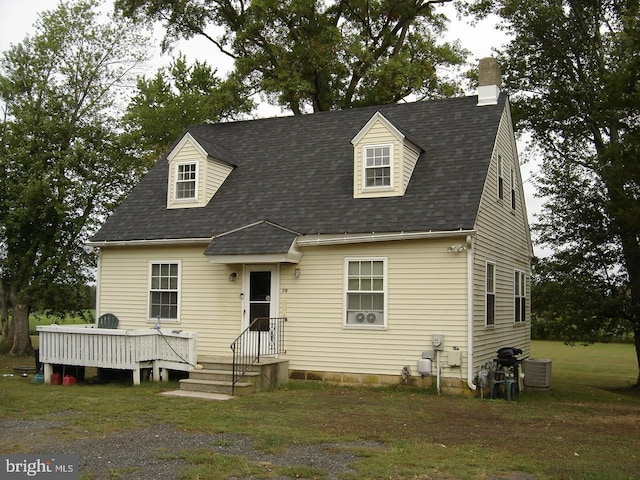 cape cod house featuring a wooden deck, a front lawn, and central AC