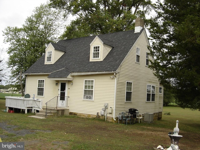 cape cod home featuring a front yard, a deck, and central AC unit