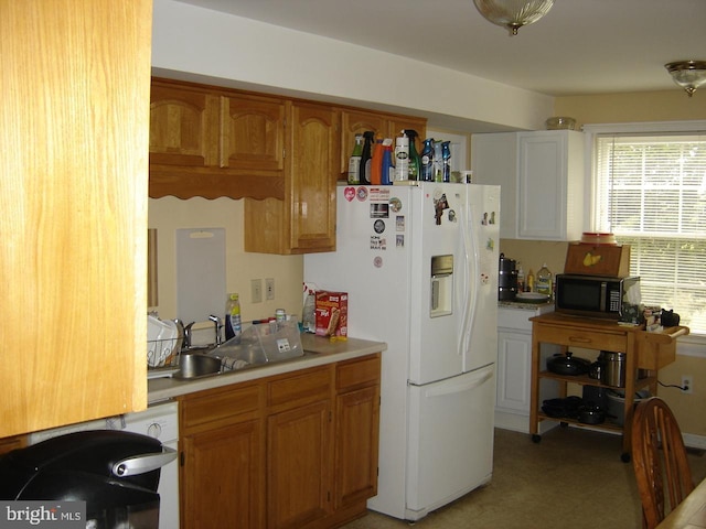 kitchen featuring white fridge with ice dispenser and sink