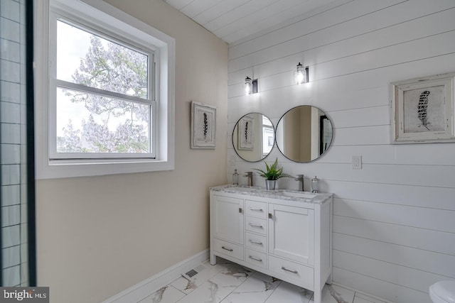 bathroom with vanity and wood walls