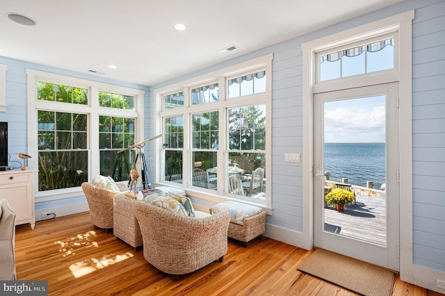 sunroom featuring a water view