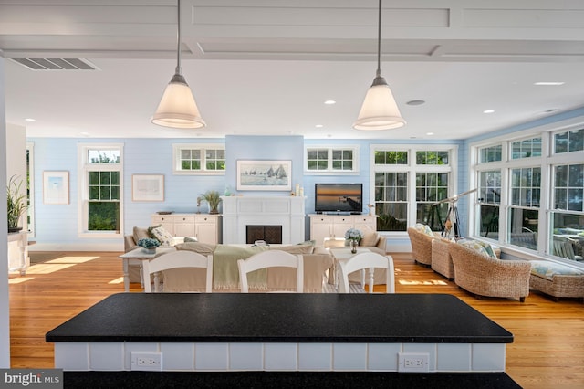 kitchen featuring white cabinetry, light hardwood / wood-style flooring, and decorative light fixtures