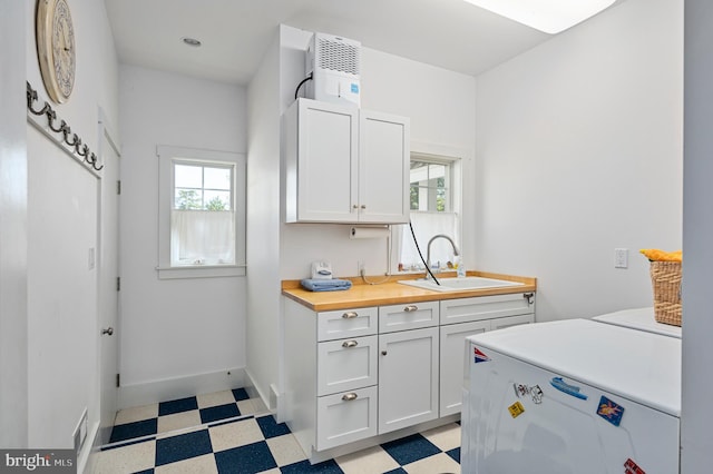 kitchen with refrigerator, white cabinets, sink, and wood counters