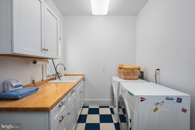 laundry area with washer and clothes dryer, sink, and cabinets