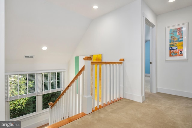 hallway with light carpet and lofted ceiling