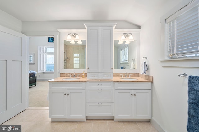 bathroom featuring walk in shower, lofted ceiling, vanity, and a wealth of natural light