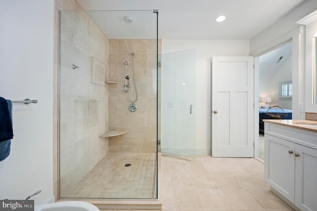 bathroom with walk in shower, vanity, and tile patterned floors