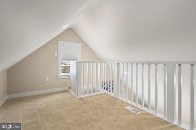 bonus room with light colored carpet and lofted ceiling