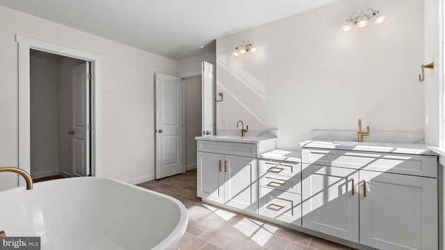 bathroom featuring tile patterned flooring, vanity, and a tub to relax in