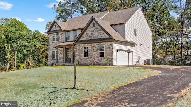 view of front of property with a front lawn, cooling unit, and a garage