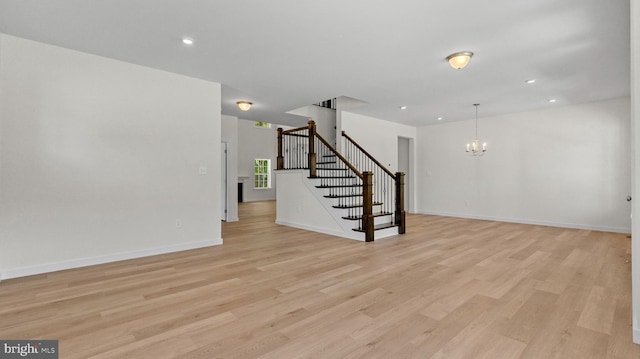 unfurnished living room with a chandelier and light hardwood / wood-style flooring