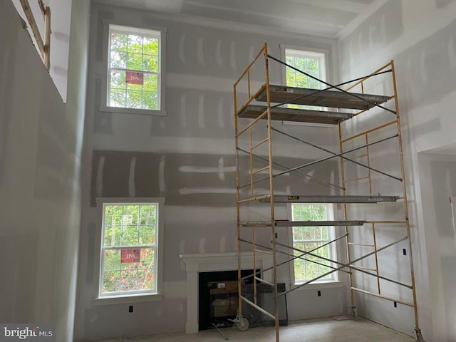 staircase with concrete flooring, a fireplace, and a wealth of natural light