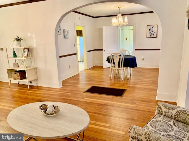 dining room with ornamental molding, hardwood / wood-style floors, and an inviting chandelier