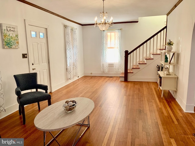 entryway featuring wood-type flooring, ornamental molding, and a notable chandelier