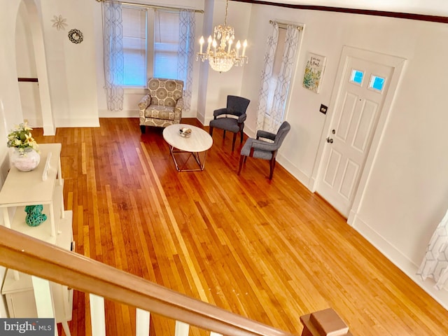 foyer with an inviting chandelier and hardwood / wood-style flooring