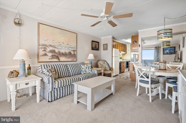 living room featuring light carpet, crown molding, and ceiling fan