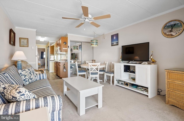 living room with light carpet, ornamental molding, and ceiling fan