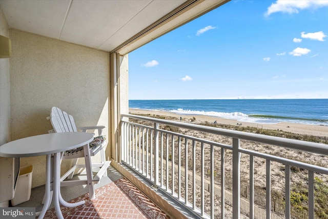 balcony with a water view and a beach view