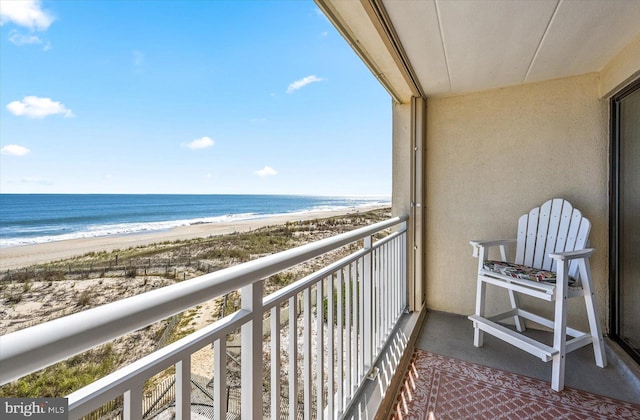 balcony featuring a water view and a beach view