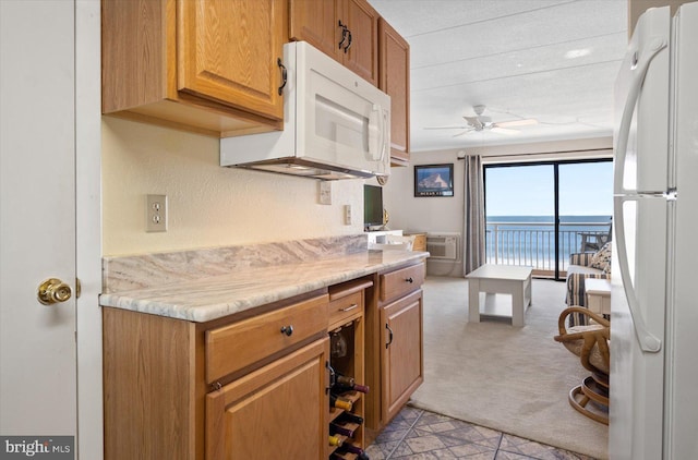 kitchen with a textured ceiling, ceiling fan, light colored carpet, and white appliances