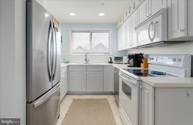 kitchen featuring light tile patterned floors, appliances with stainless steel finishes, and sink