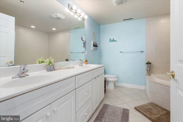 bathroom featuring tile patterned floors, tiled tub, vanity, and toilet