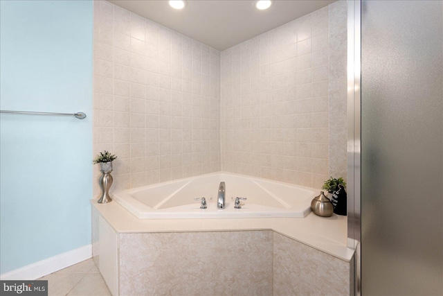 bathroom with tiled bath and tile patterned floors