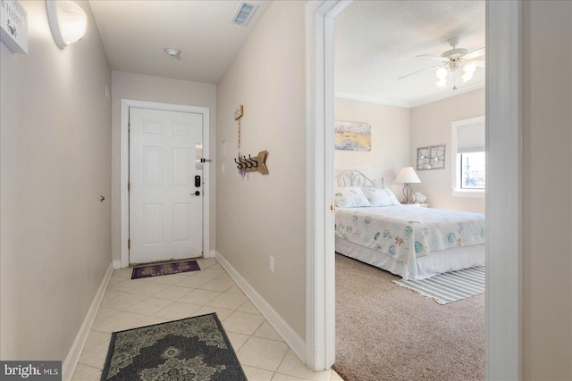 entryway with ceiling fan, light carpet, and ornamental molding