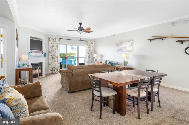 dining area featuring light carpet, ceiling fan, and crown molding