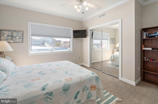 bedroom with ornamental molding, a closet, carpet, and ceiling fan