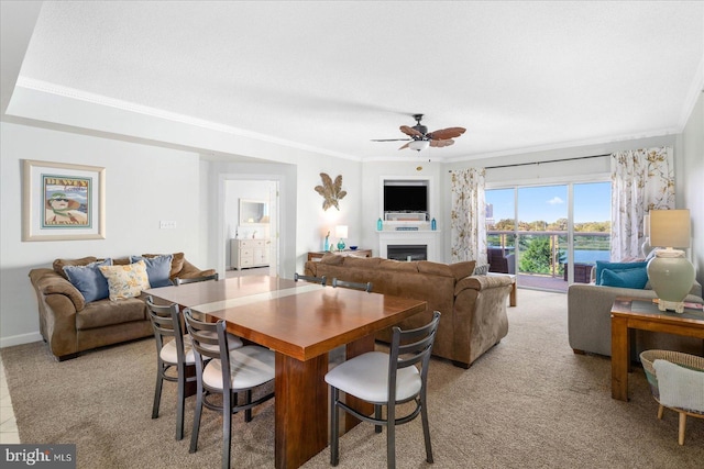 carpeted dining space with ornamental molding and ceiling fan