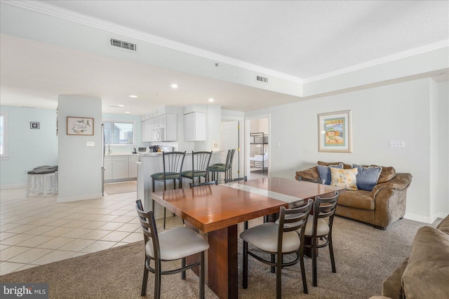 tiled dining space featuring a textured ceiling and ornamental molding