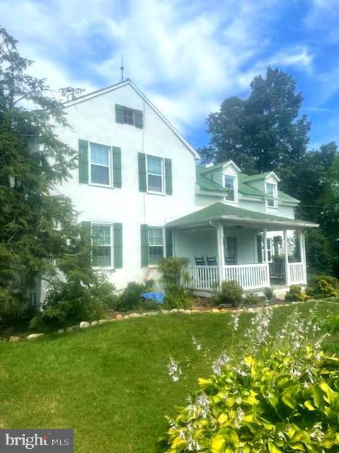 rear view of property with a porch and a lawn