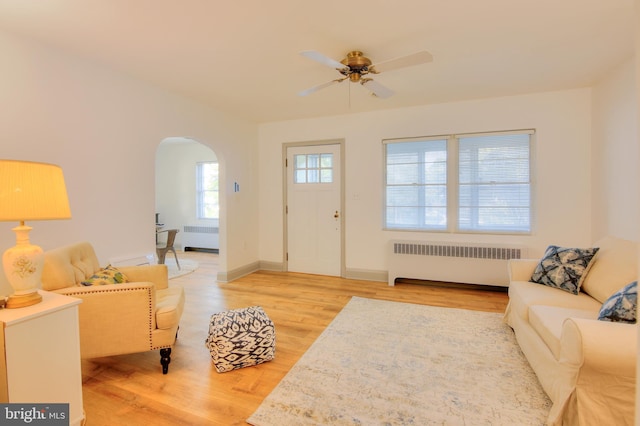 living room with ceiling fan, radiator, and hardwood / wood-style floors